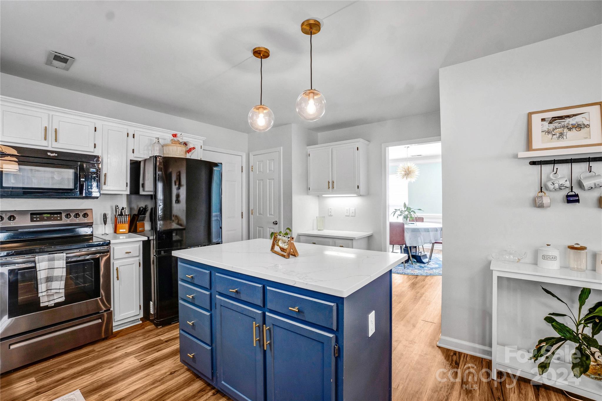 12502 Chickasaw Drive Huntersville, NC 28078 - Photo 11 of 39 a kitchen with a refrigerator a stove cabinets and a dining table