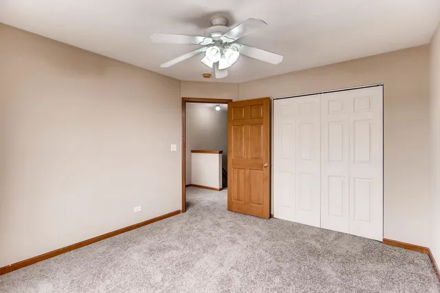 a view of an empty room with a chandelier fan