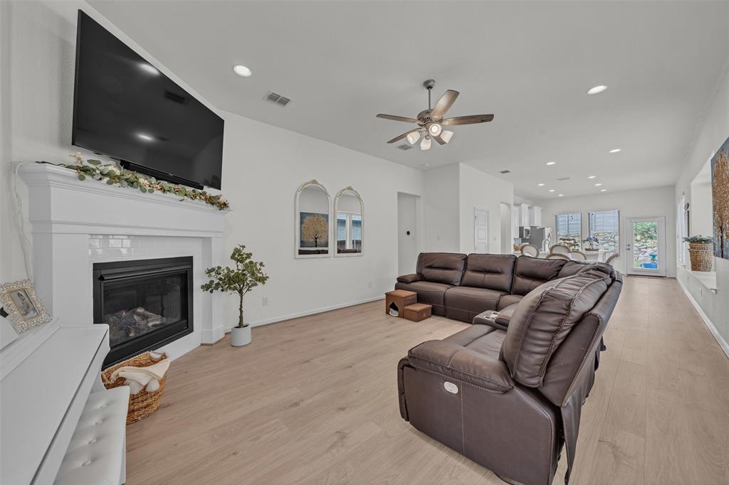 228 Palo Duro Bend Rhome, TX 76078 - Photo 23 of 35 a living room with furniture a fireplace and a flat screen tv