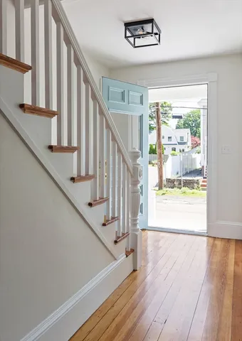 a view of staircase with wooden floor and white walls