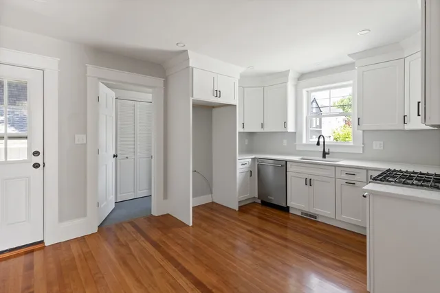 a kitchen with stainless steel appliances granite countertop a stove a sink and a microwave