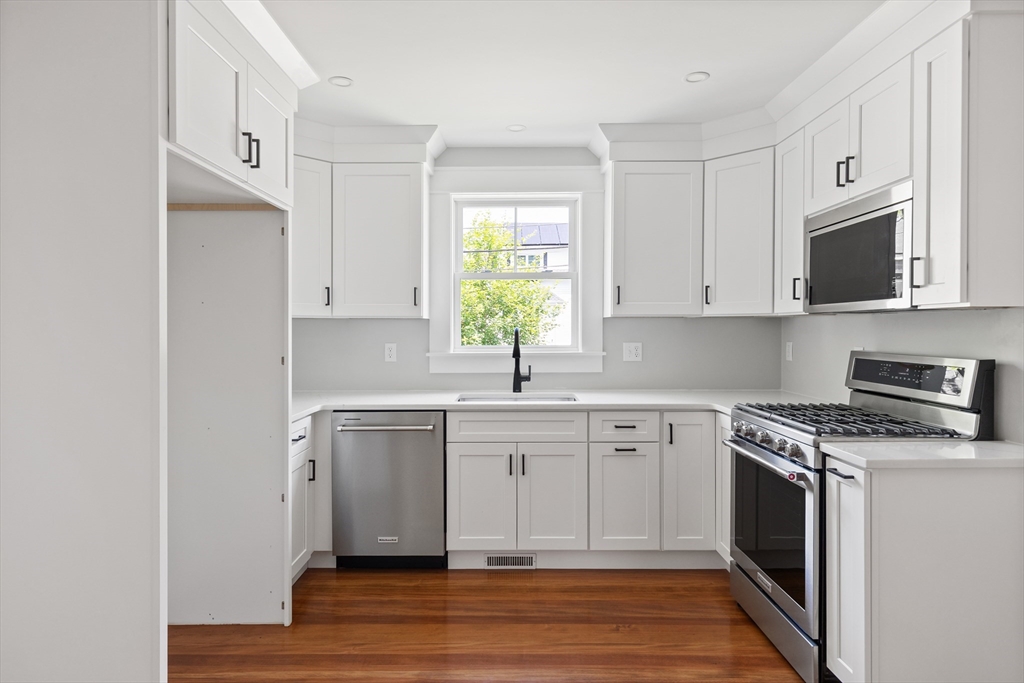8 Florence Street Natick, MA 01760 - Photo 23 of 38 a kitchen with stainless steel appliances granite countertop a stove a sink and a microwave