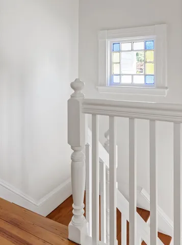 a view of an empty room with wooden floor and window