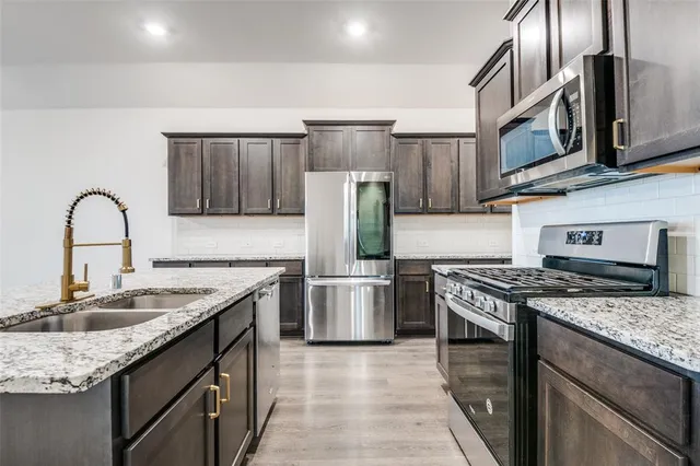 a kitchen with stainless steel appliances granite countertop a stove sink and cabinets