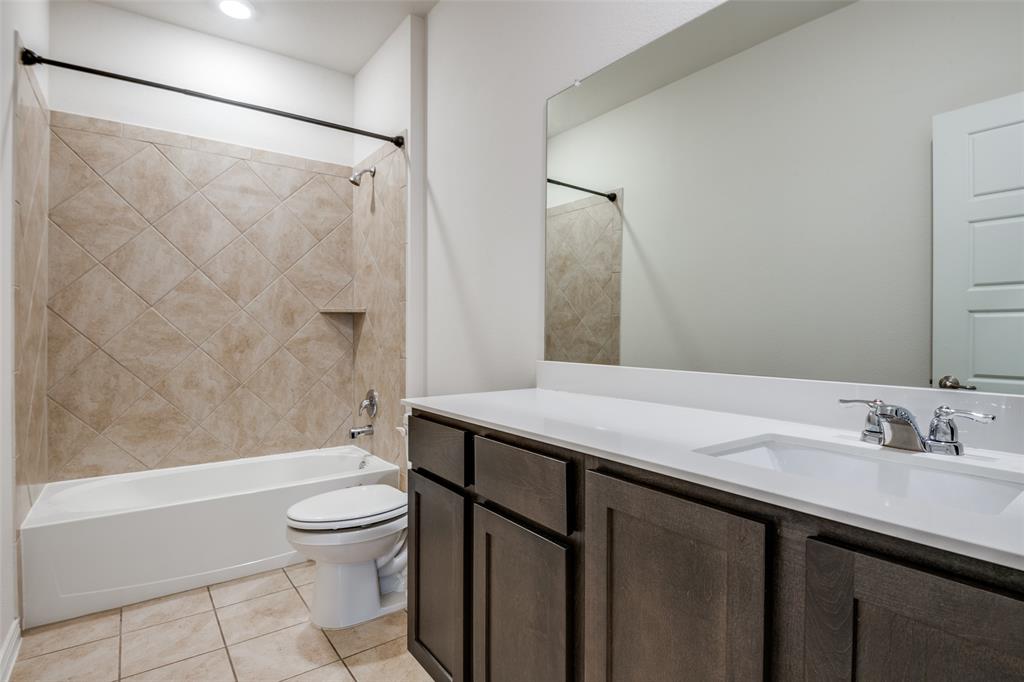 905 Philadelphia Street Fate, TX 75189 - Photo 15 of 25 a bathroom with a granite countertop sink toilet and shower