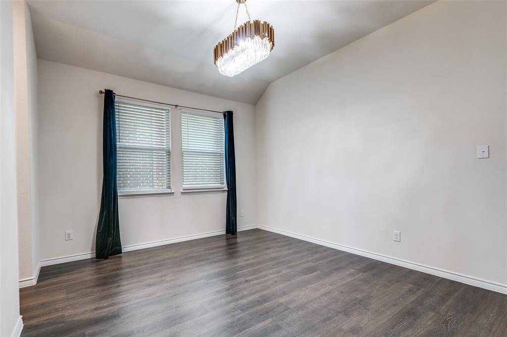 905 Philadelphia Street Fate, TX 75189 - Photo 16 of 25 an empty room with wooden floor chandelier and windows
