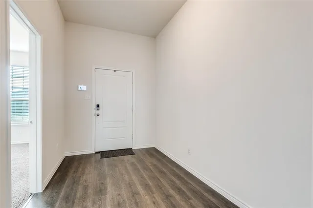 a view of a small space with wooden floor and a window