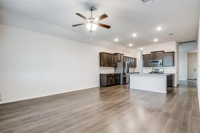 a view of kitchen with refrigerator microwave and stove
