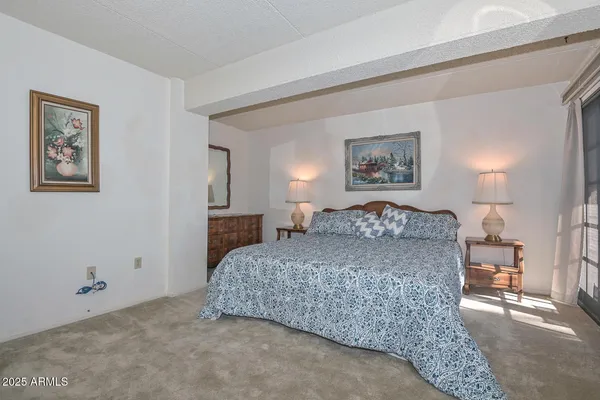 a bedroom with a bed and a painting on the wall