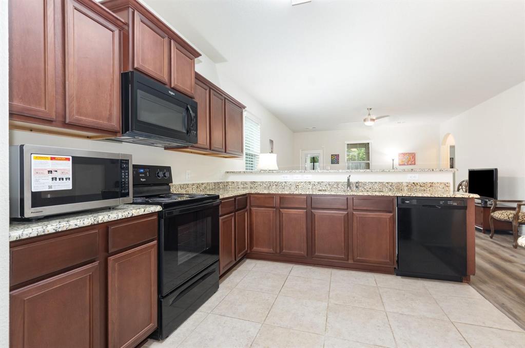 1906 Pilot Point Way Princeton, TX 75407 - Photo 6 of 14 a kitchen with stainless steel appliances granite countertop a stove microwave and sink
