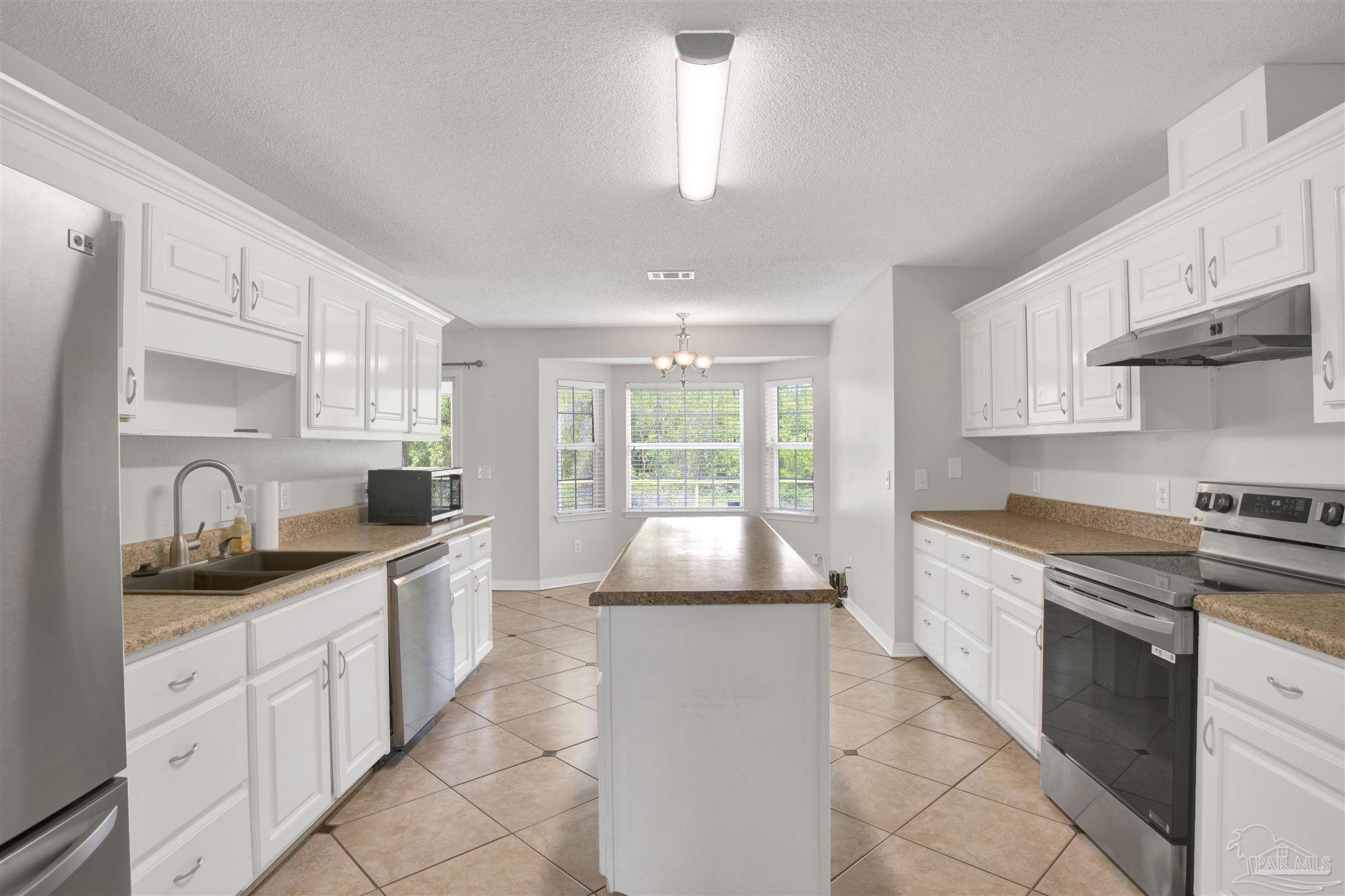 128 Gunwale Road Pensacola, FL 32507 - Photo 13 of 34 a kitchen with granite countertop a sink stove and cabinets