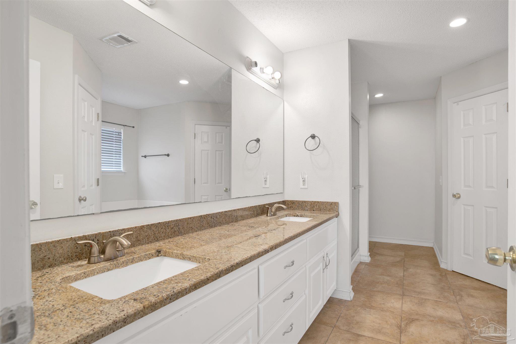 128 Gunwale Road Pensacola, FL 32507 - Photo 17 of 34 a spacious bathroom with a granite countertop sink mirror and double
