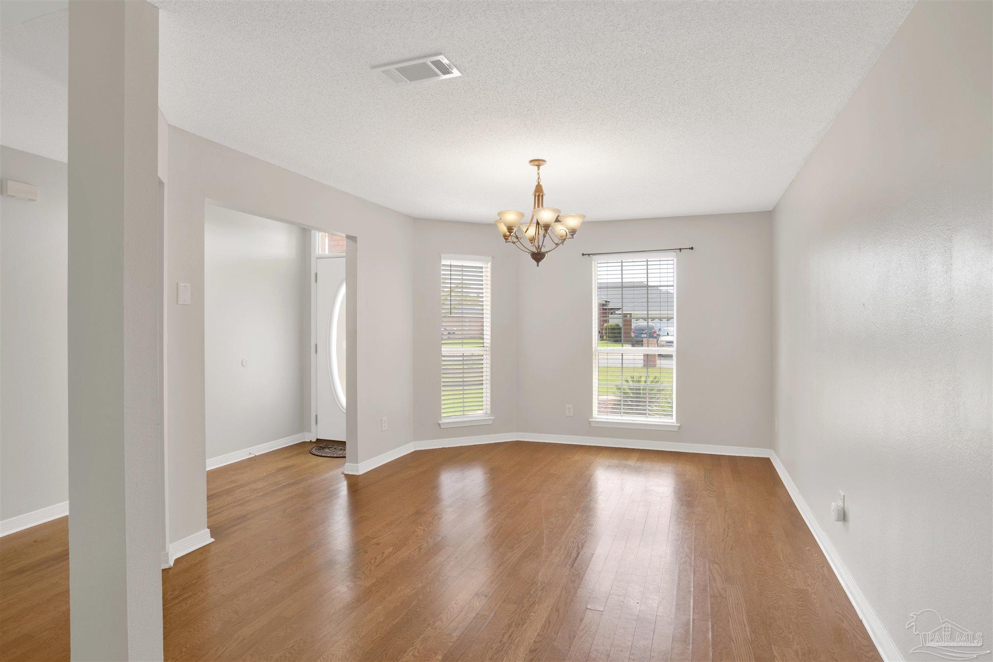 128 Gunwale Road Pensacola, FL 32507 - Photo 4 of 34 an empty room with wooden floor and windows