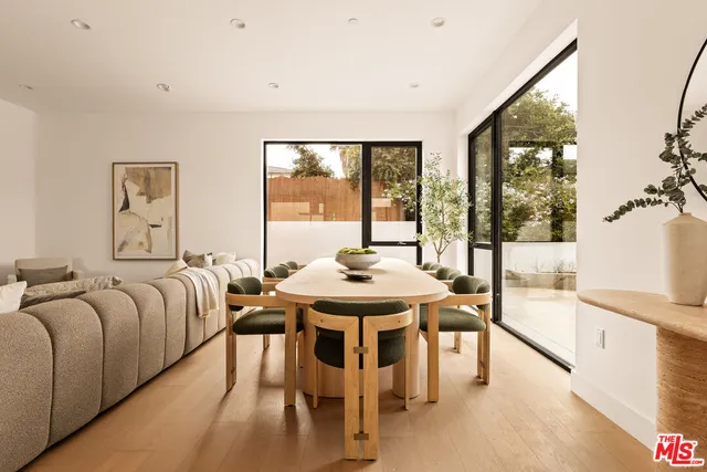 a living room with furniture a large window and a wooden floor