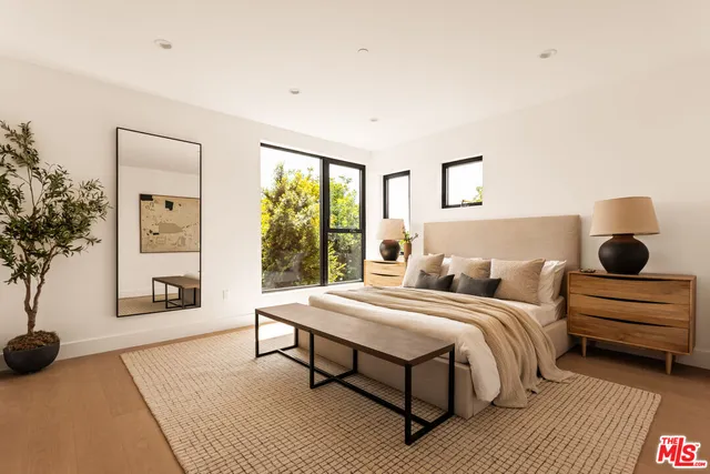 a bedroom with a bed a bookshelf and a window