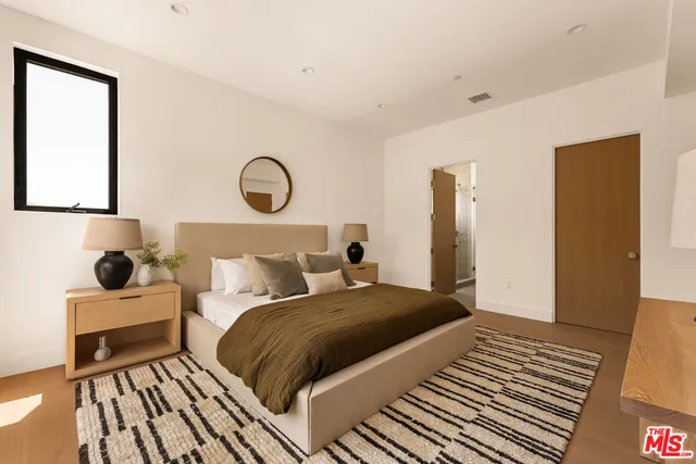 a bedroom with a bed and wooden floor