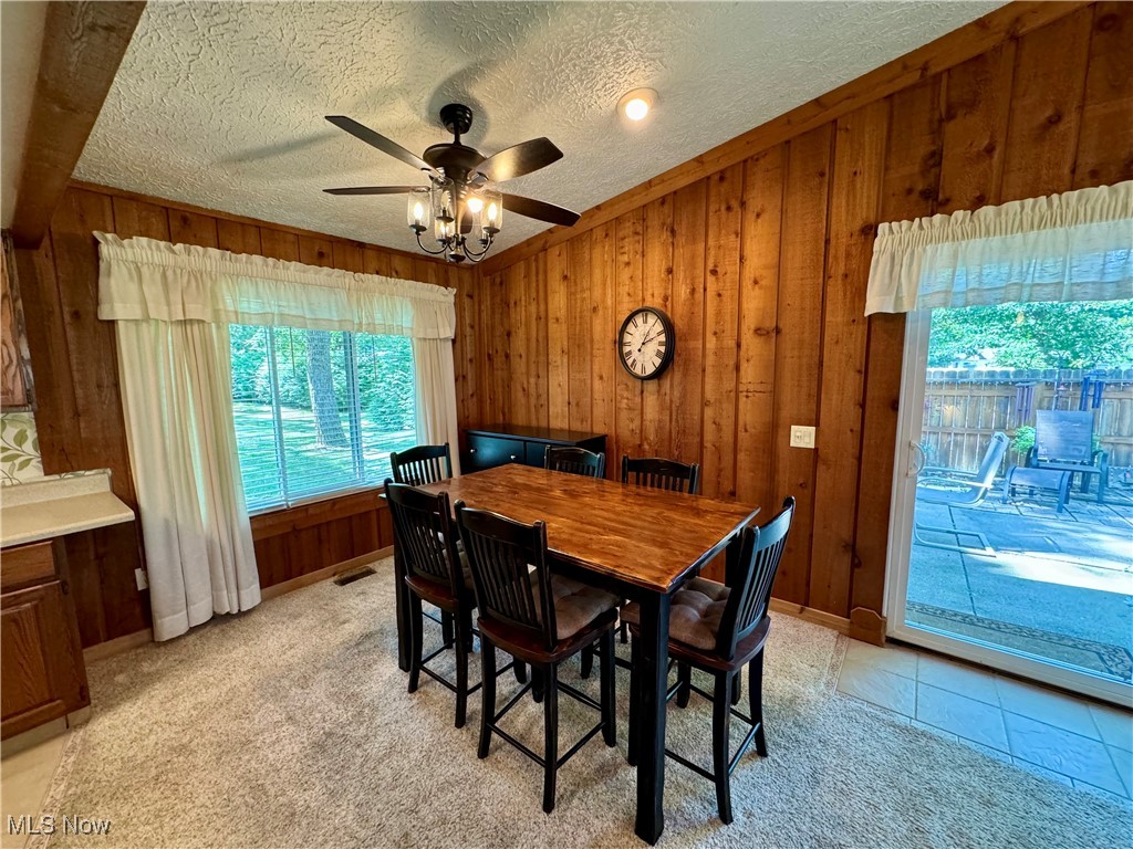 1499 Welch Road Painesville, OH 44077 - Photo 12 of 22 Dining area featuring light colored carpet, ceiling fan, and wooden walls