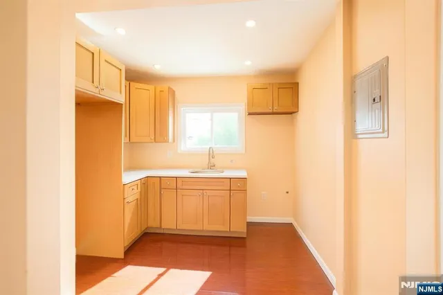 a view of empty room with wooden floor and windows