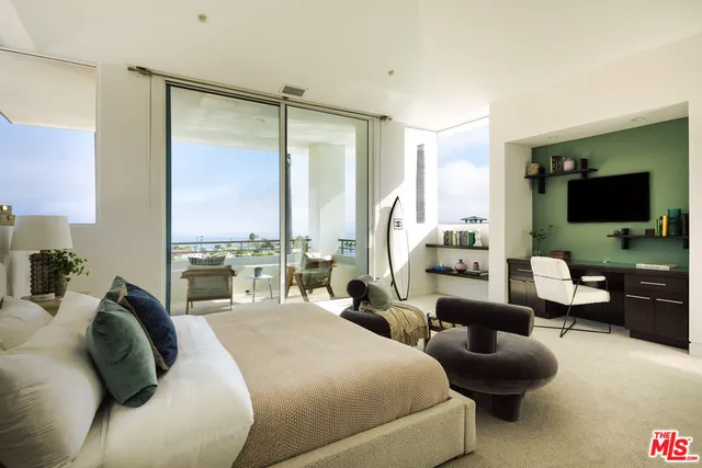 a large bedroom with a large bed and flat screen tv