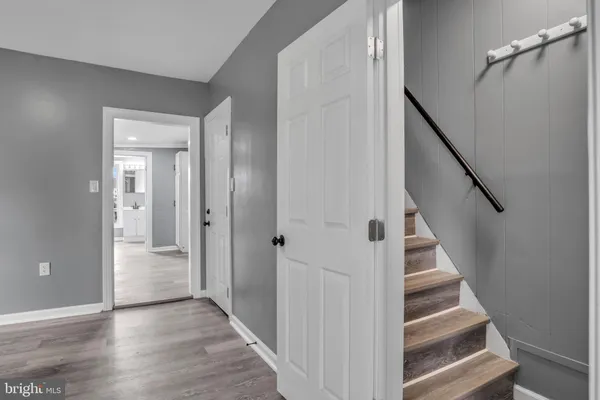 a view of a hallway with wooden floor and entryway