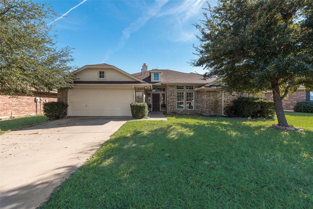 View of front of home featuring a front lawn and a garage