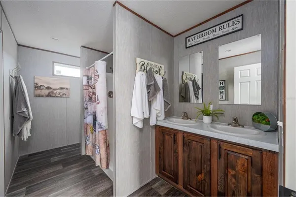 a bathroom with a granite countertop sink a mirror a shower and a window