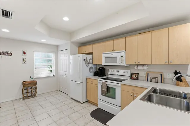 a kitchen with white cabinets and white appliances