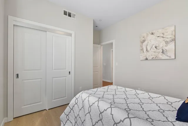 a bedroom with a bed and painting on the wall