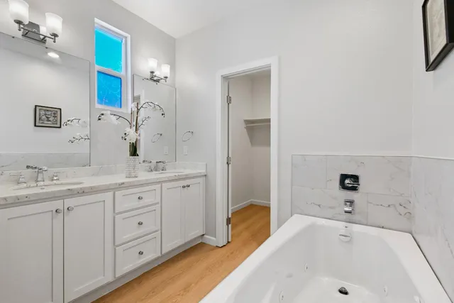 a bathroom with a tub sink and mirror