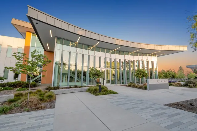 a building with glass windows and yard