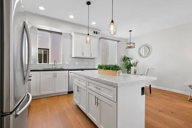 a kitchen with kitchen island white cabinets and white appliances
