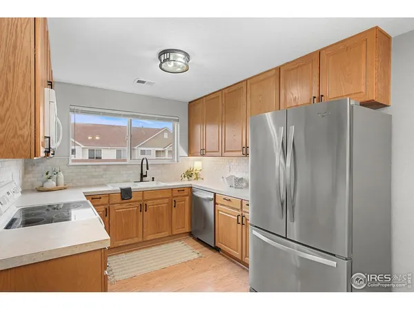 a kitchen with stainless steel appliances wooden cabinets a sink and a refrigerator