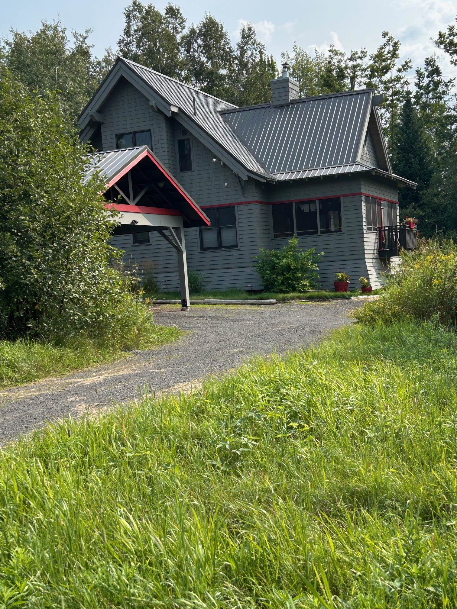 View of front of house with a metal roof and a chimney