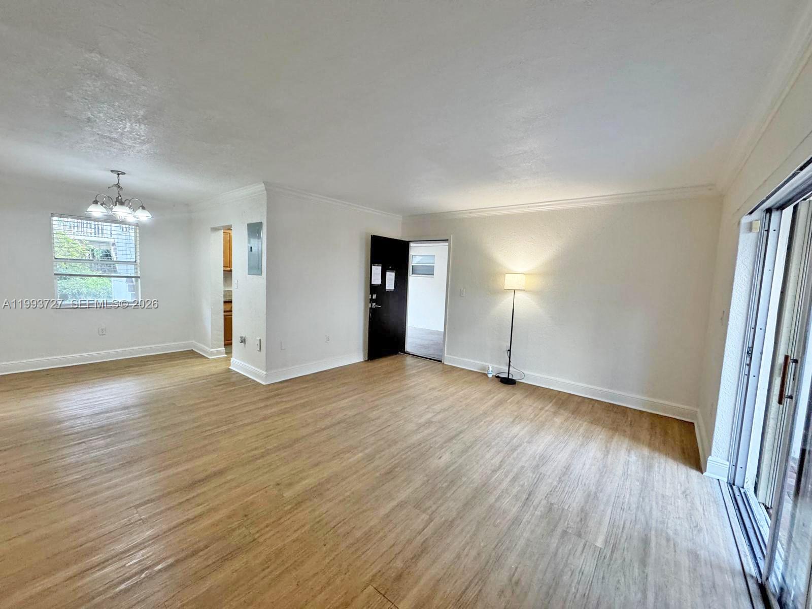 8475 Southwest 94th Street, Unit 119E Miami, FL 33156 - Photo 1 of 15 an empty room with wooden floor and windows