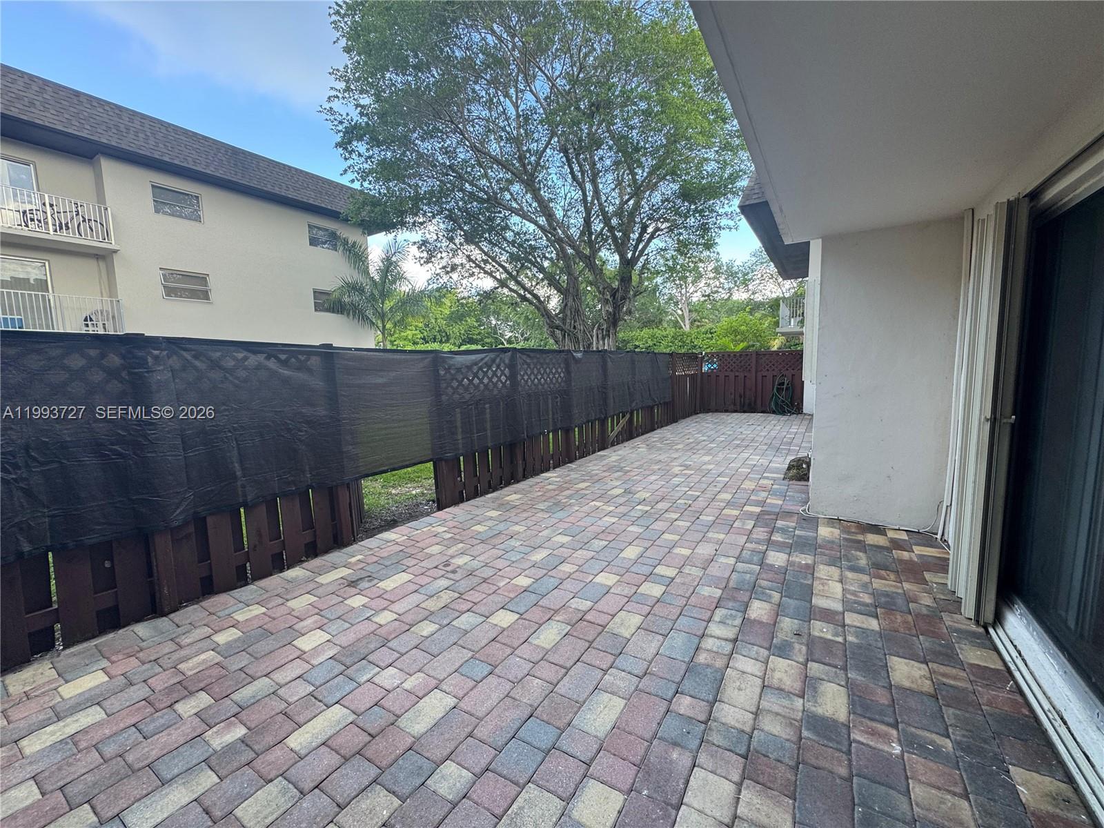 8475 Southwest 94th Street, Unit 119E Miami, FL 33156 - Photo 12 of 15 a view of backyard with wooden fence and trees