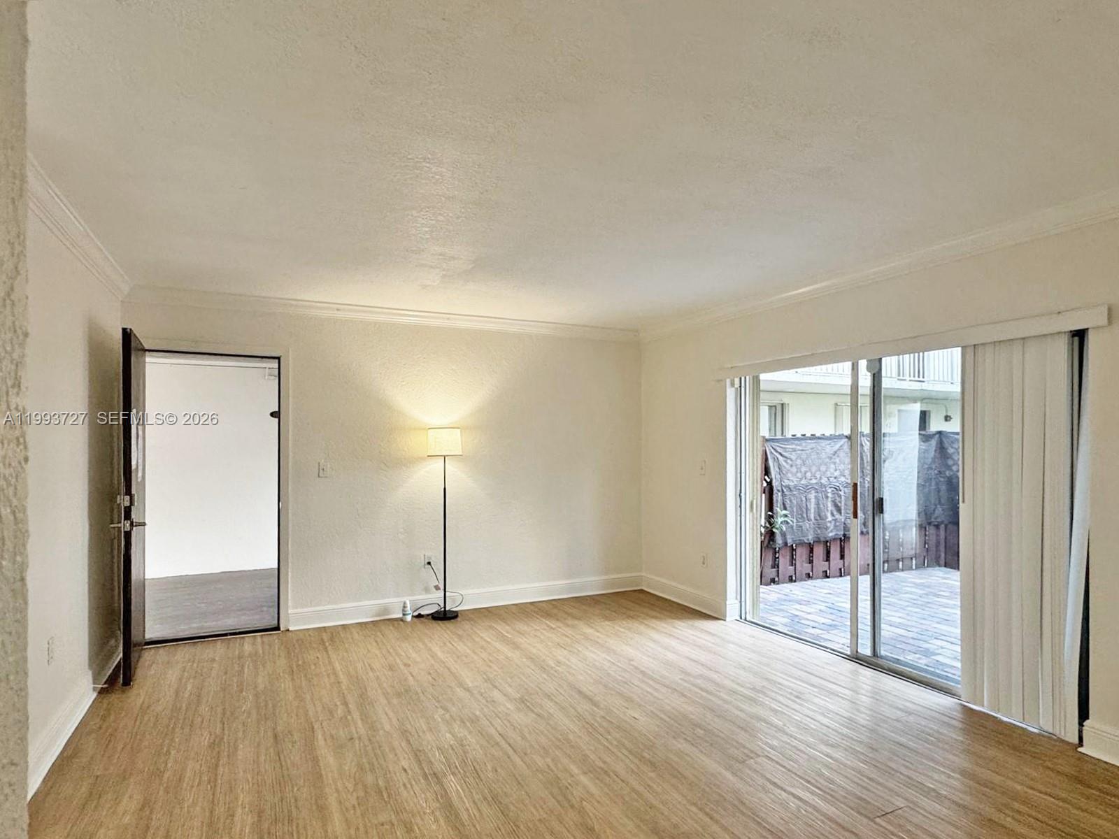 8475 Southwest 94th Street, Unit 119E Miami, FL 33156 - Photo 2 of 15 a view of an empty room with wooden floor and a window