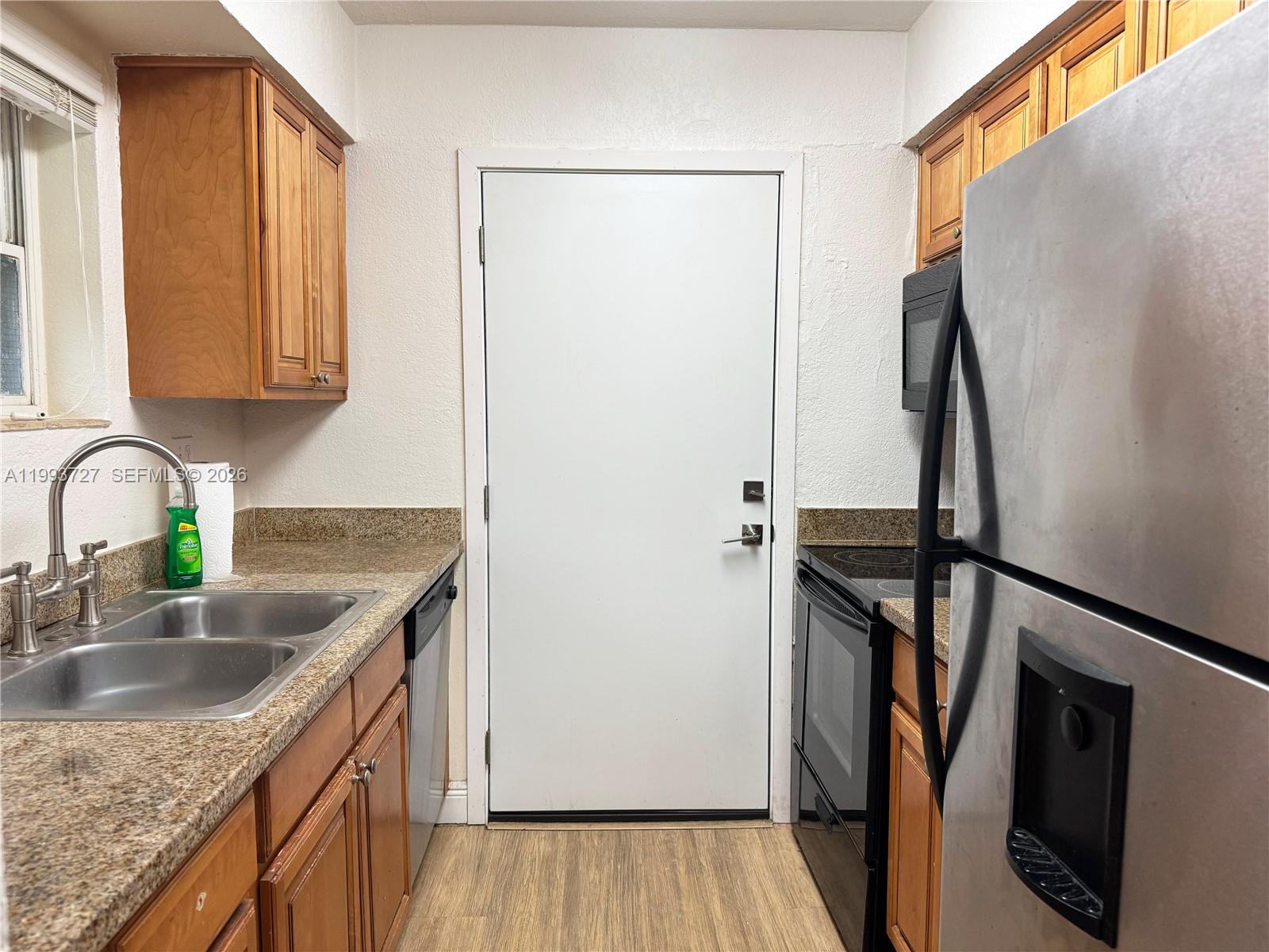 8475 Southwest 94th Street, Unit 119E Miami, FL 33156 - Photo 4 of 15 a kitchen with sink a refrigerator and a granite counter tops
