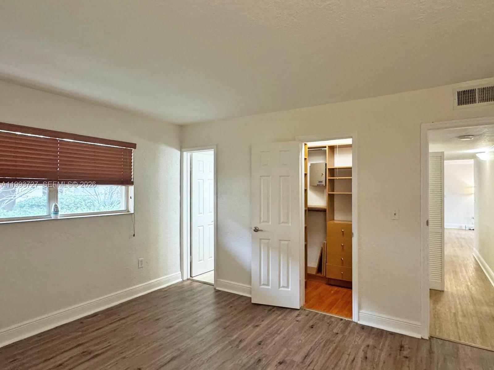 8475 Southwest 94th Street, Unit 119E Miami, FL 33156 - Photo 6 of 15 an empty room with wooden floor and windows