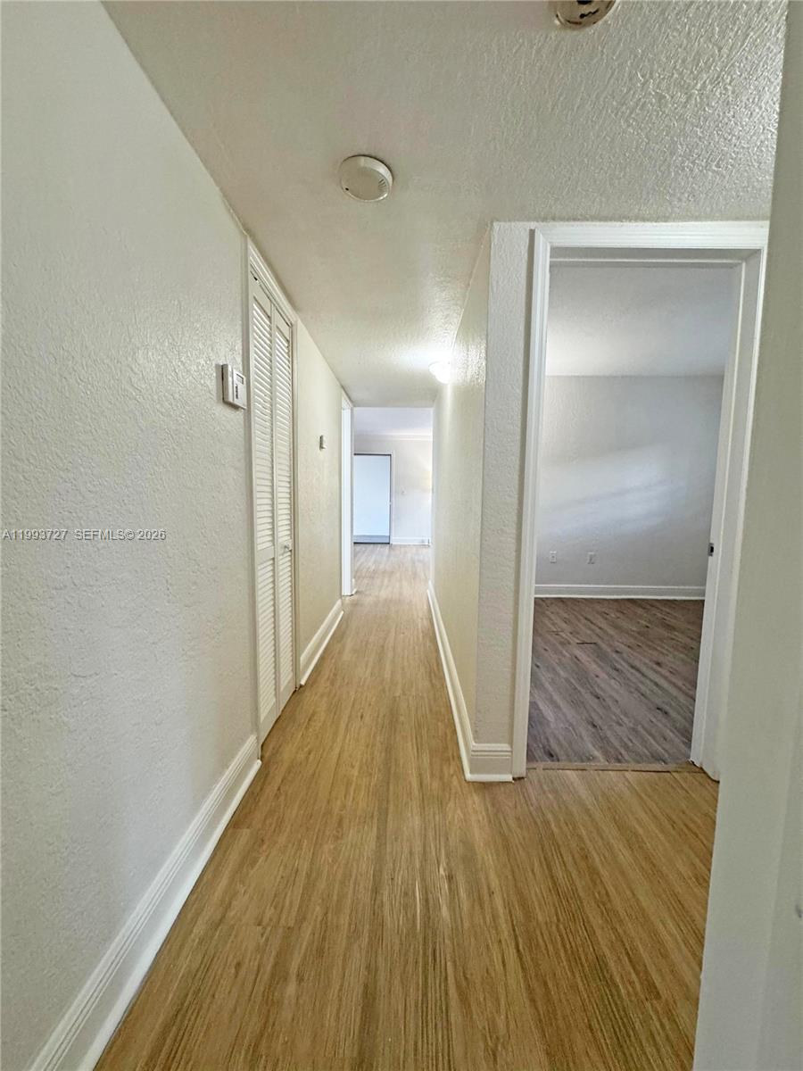8475 Southwest 94th Street, Unit 119E Miami, FL 33156 - Photo 9 of 15 a view of a hallway with wooden floor