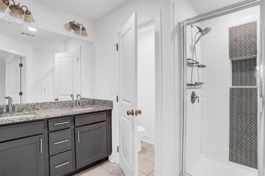 7788 Baron Road Fairburn, GA 30213 - Photo 11 of 17 a bathroom with a granite countertop sink toilet and shower