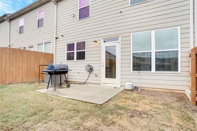 a backyard of a house with barbeque oven table and chairs
