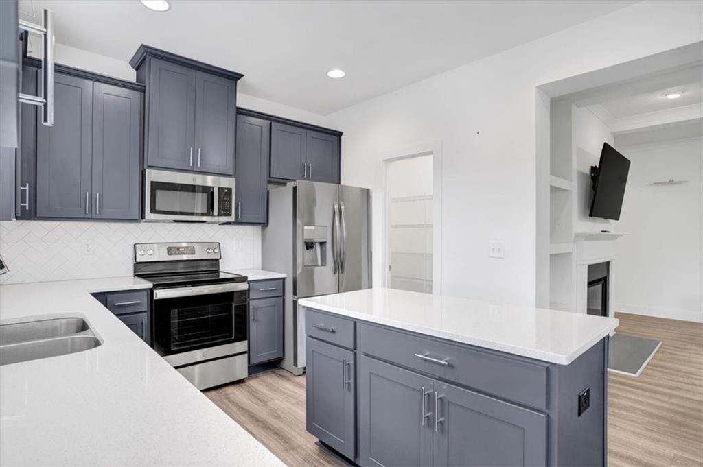 7788 Baron Road Fairburn, GA 30213 - Photo 7 of 17 a kitchen with stainless steel appliances a stove microwave and refrigerator