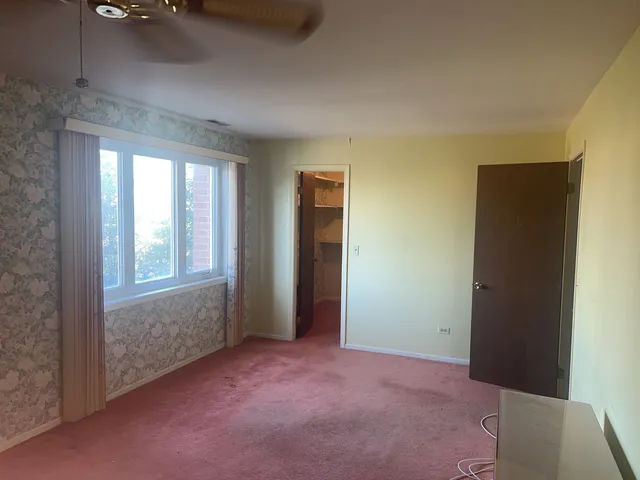 an empty room with windows and closet