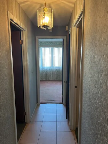 a view of a hallway with a chandelier and livingroom view