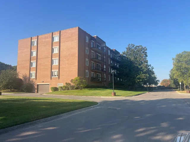 a view of a building with a big yard and a palm tree