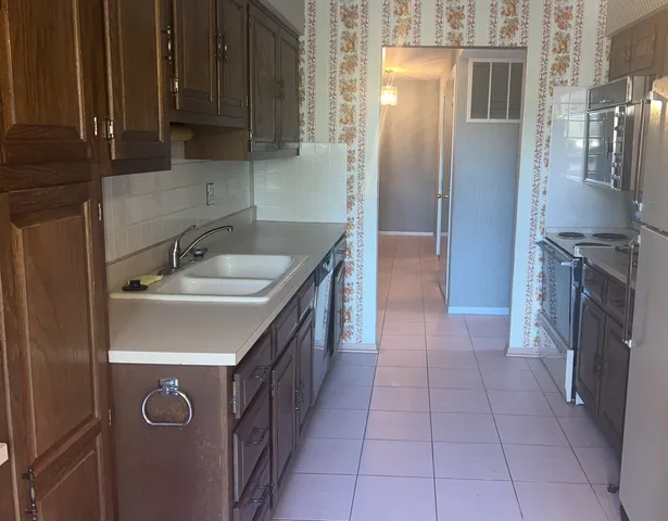 a kitchen with a sink a refrigerator and cabinets