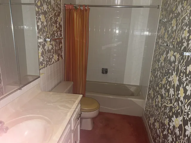 a bathroom with a granite countertop sink toilet and shower