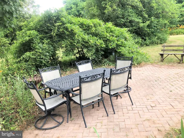 a view of a chairs and table on the backyard