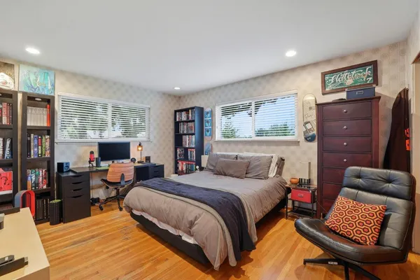 a bedroom with a bed and wooden floor