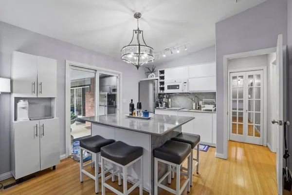 a dining room with stainless steel appliances kitchen island granite countertop furniture and wooden floor